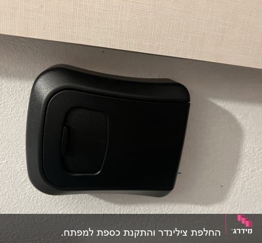 קופסת מפתחות שחורה מותקנת על קיר לבן
